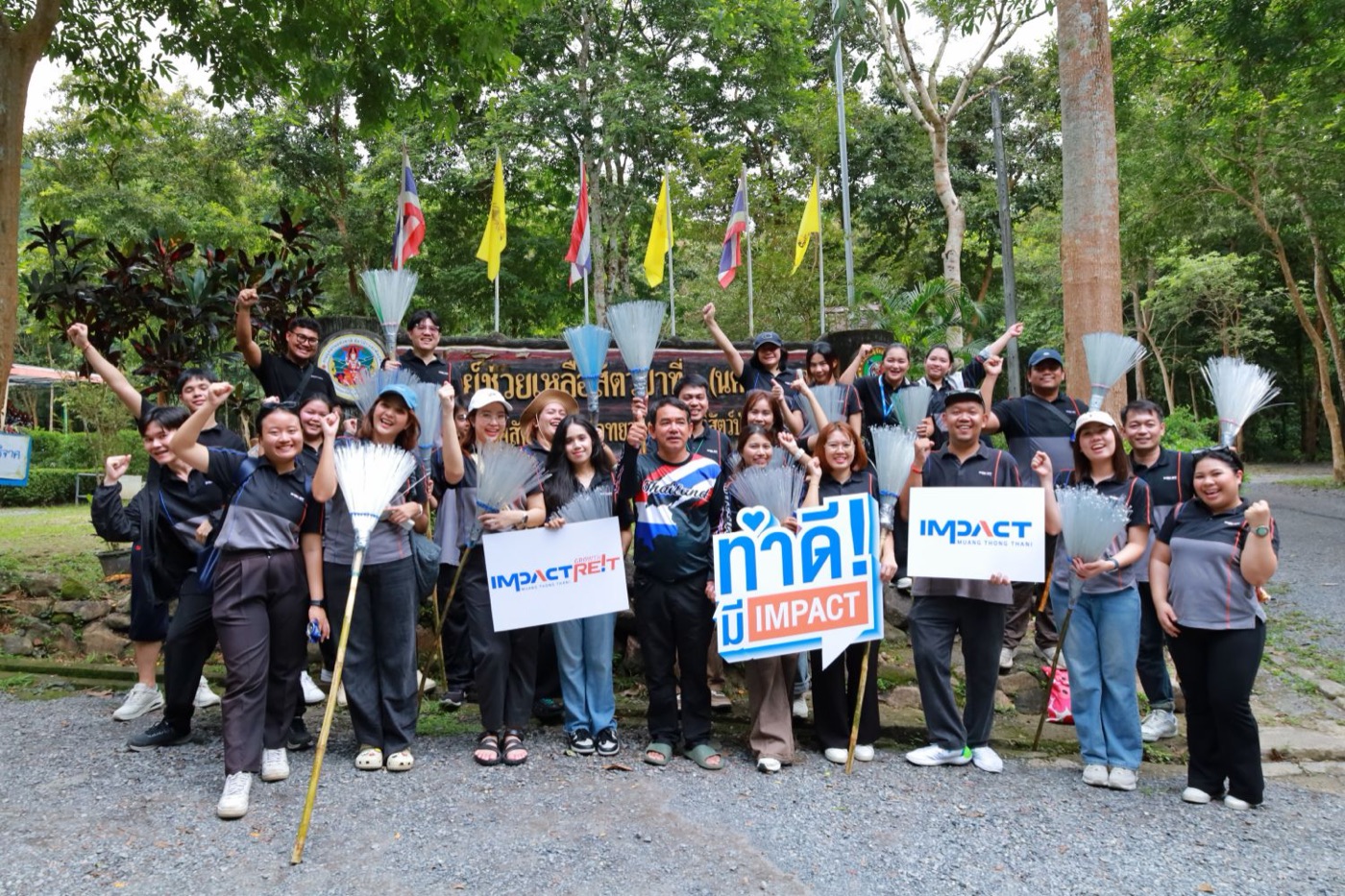 พนักงาน IMPACT ถือไม้กวาดและป้าย ทำดี! มี IMPACT ถ่ายรูปรวมกันในกิจกรรมจิตอาสา
